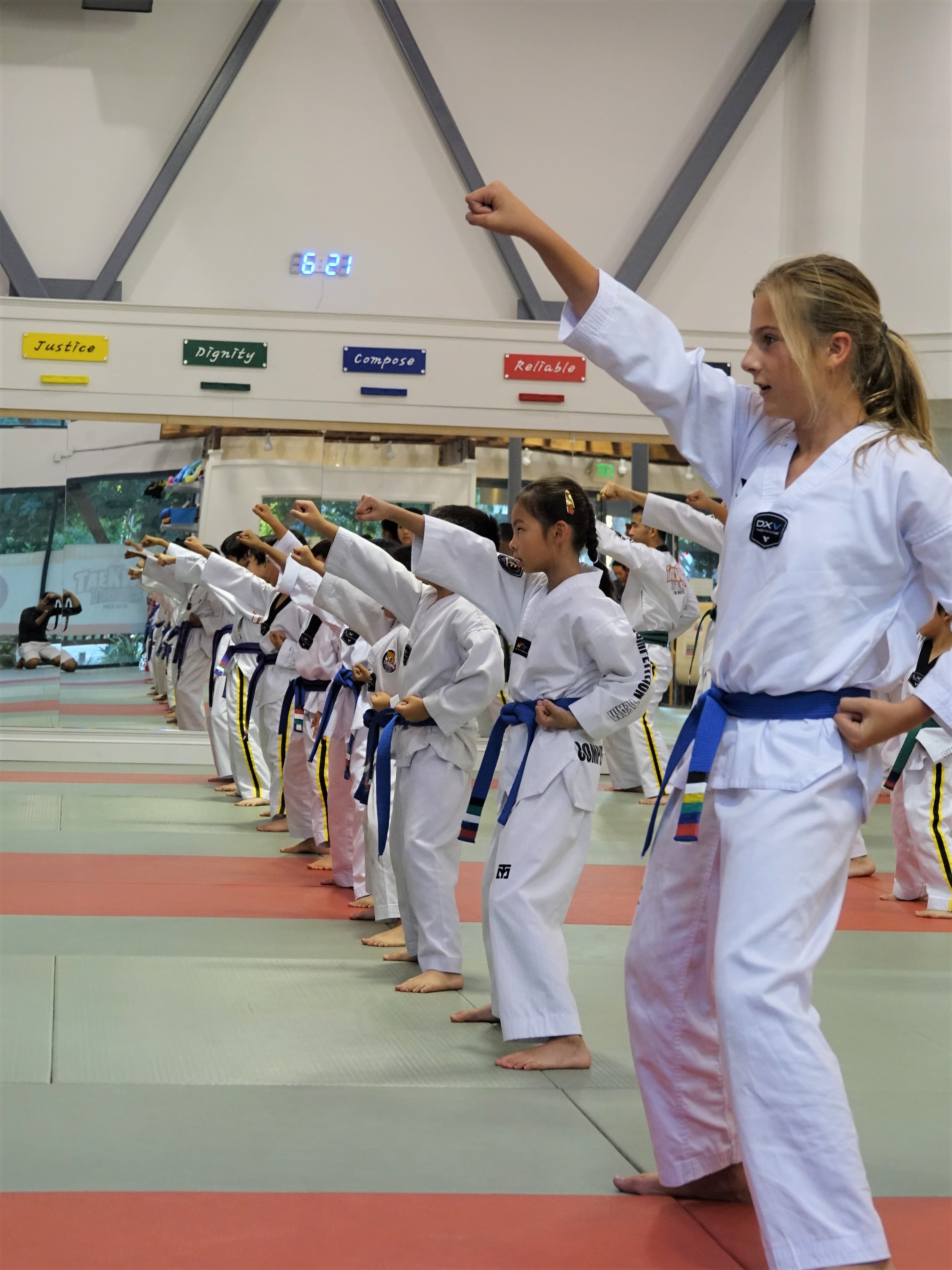 Teens and adults practicing advanced Taekwondo techniques